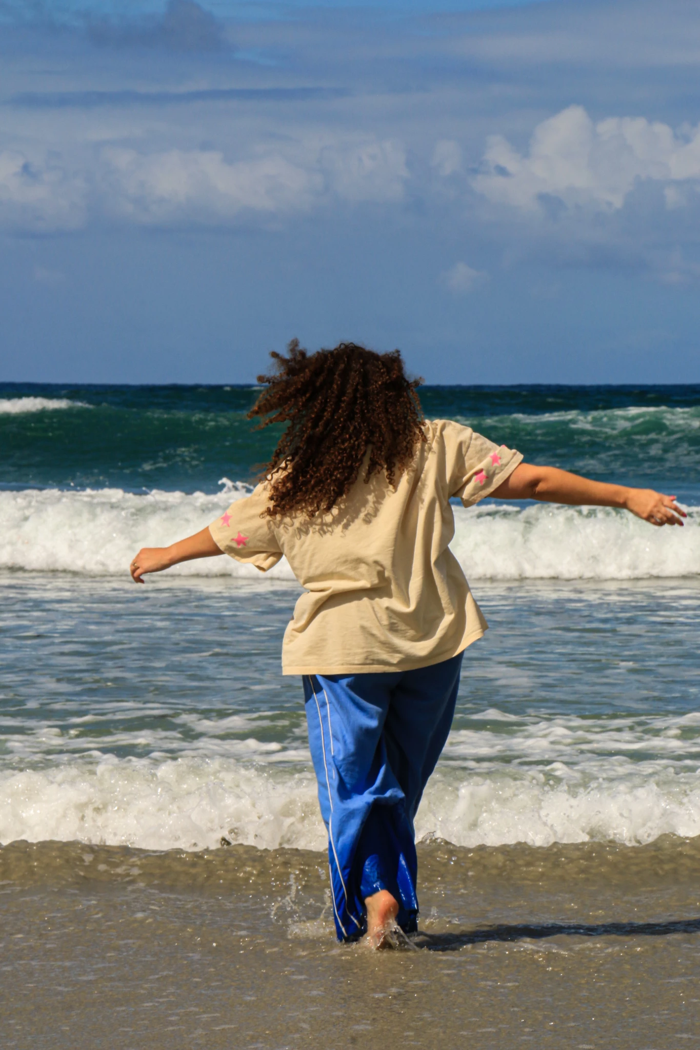 Woman with arms outstretched in the sea surf